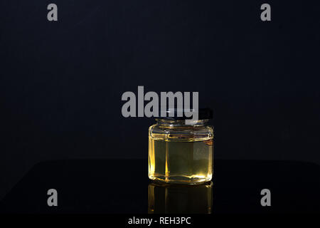 Trüffel Pilz in ein Glas Honig auf schwarzem Hintergrund. Minimalismus in der Komposition. Luxus essen. Freier Platz für Text Stockfoto