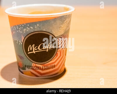 PARIS, FRANKREICH, November circa, 2018. In der Nähe von McDonald's Papier Tasse Kaffee auf den Tisch. Mac/Brand auf einem gelben Tabelle in Paris Airport Stockfoto