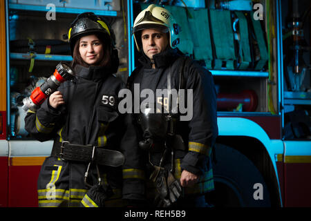 Bild von Feuerwehrmann und die Frau in der Nähe von Feuer Lkw Stockfoto