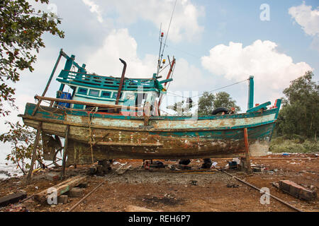 Eine verwesende alten kambodschanischen Holz Fischerboot auf unterstützt im Trockendock zu restaurieren. Stockfoto