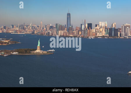 Helikopterblick auf Freiheitsstatue auf Hintergrund downtown Manhattan. Luftaufnahme. Liberty IslandManhattan, New York City, New York. Stockfoto