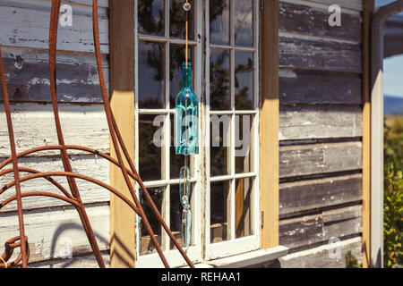 Blue Wind Chimes garten Kunst aus einem Glas Flasche vor ein Fenster gemacht Stockfoto