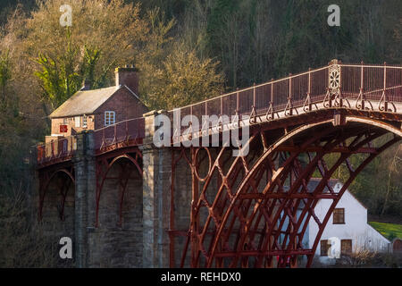 Winter Sonnenlicht hebt die rote Farbe des Eisernen Brücke über den Fluss Severn an Ironbridge, Shropshire, England, Grossbritannien, die Toll House. Stockfoto