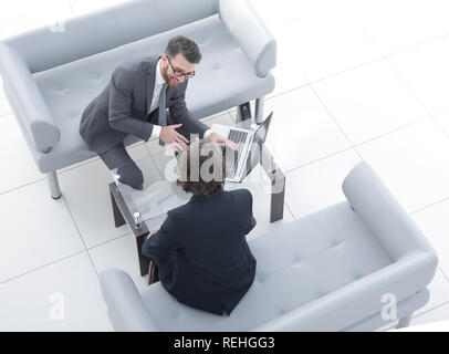 Zwei Geschäftsleute über Aufgaben im Büro sitzen. Stockfoto