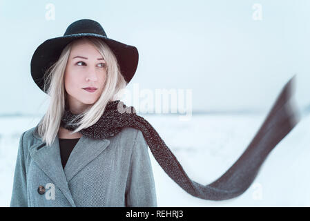 Junge Frau mit Kopftuch in der windigen im Winter Feld Stockfoto