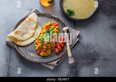 Im indischen Stil Rührei mit Akuri paratha, Dahl und Eistee, kopieren Raum Stockfoto