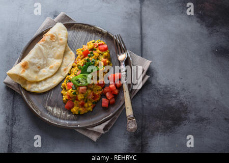 Rührei mit Tomaten und Schnittlauch auf Platte, Platz kopieren Stockfoto