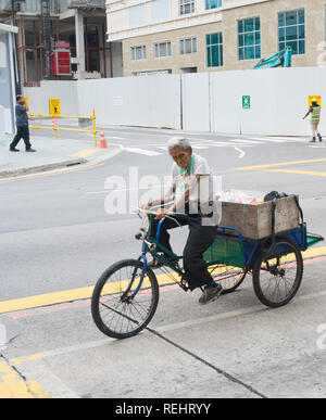 Singapur - 18. FEBRUAR 2017: Mann, ein Dreirad auf der Straße in Singapur. Singapur ist der wichtigste Finanzplatz in Asien Stockfoto