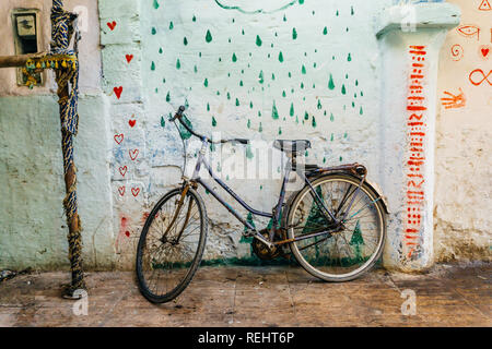 Alten rustikalen Vintage Fahrrad auf der Straße in der Nähe der Farbe an der Wand. Travel Concept. Fahrt mit dem Fahrrad. Postkarte. Kopieren Sie Platz. Stockfoto