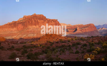 USA, Utah, Capitol Reef National Park, Sonnenuntergang am Schloss und andere Sandstein Felsformationen entlang der Waterpocket Fold; Ansicht von Osten Panorama Punkt. Stockfoto