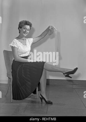 Nylon strümpfe in den 1940er Jahren. Eine Frau zeigt, wie gut Ihr nylon strümpfe auf ihre Beine fit und hält einen Strumpf in der Hand. Schweden 1940. Foto Kristoffersson ref 43 K-27 Stockfoto
