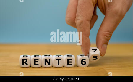 Ruhestand mit 65 oder 67? Hand dreht einen Würfel und Änderungen der Ausdruck "Rente 65" in "Rente 67" (Deutsch für die Rente mit 65 oder Rente mit Stockfoto