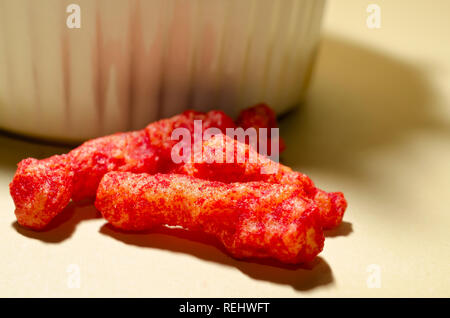 Eine enge Sicht der Flamin' Hot Cheetos enthüllt die Spicy Chili Käse Pulver Gewürz, dass Coats die aufgeblasen Maismehl Snack. Stockfoto