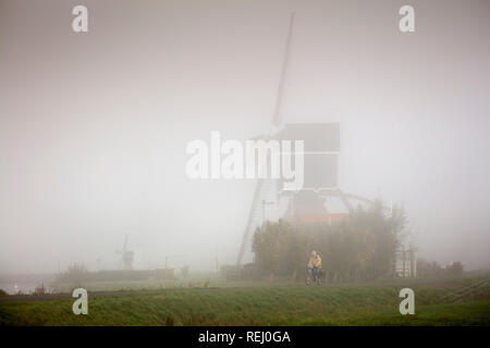 Die Niederlande, Vlist, Vlist Fluss, Windmühle namens Bon Repa, Radfahrer. Stockfoto