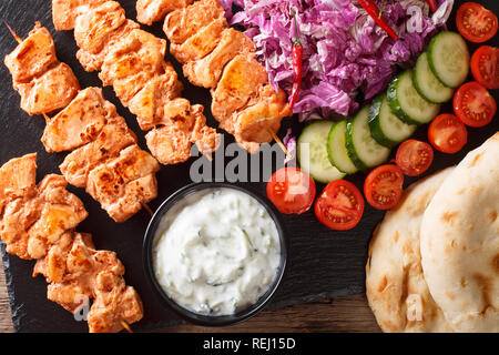 Libanesische Shish Taouk (tawook) mit frischem Gemüse, Joghurt Sauce und pita Close-up auf dem Tisch. horizontal oben Ansicht von oben Stockfoto