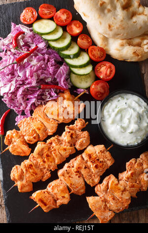 Libanesische Shish Taouk (tawook) mit frischem Gemüse, Joghurt Sauce und pita Close-up auf den Tisch. Vertikal oben Ansicht von oben Stockfoto