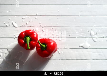 Paprika, frische rote Paprika mit Wassertropfen auf einem alten weißen Tisch gewaschen. Kopieren Sie Platz für Text. Stockfoto