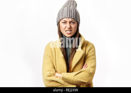 Verwirrt und beleidigt kaukasische Frau in bunten Winterkleidung im Innenbereich posing Stockfoto