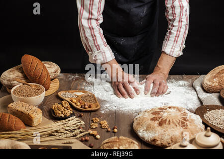 In der Nähe von Bäcker Hände kneten den Teig und die Herstellung von Brot mit einem Nudelholz. Stockfoto