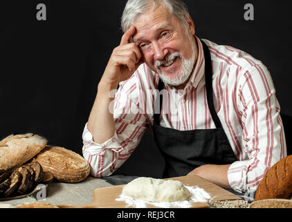 Ältere lächelnd professioneller Koch Mann. Über schwarzen Hintergrund isoliert Stockfoto