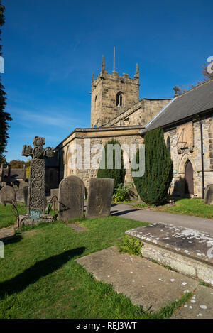 Eyam Pfarrkirche und das 8. Jahrhundert Sächsische Kreuz im historischen Dorf Eyam im Peak District National Park, Derbyshire, England. Stockfoto