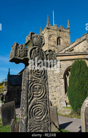 Eyam Pfarrkirche und das 8. Jahrhundert Sächsische Kreuz im historischen Dorf Eyam im Peak District National Park, Derbyshire, England. Stockfoto