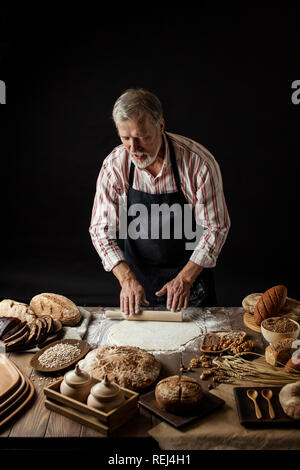 Erfahrene Bäcker Mann Vorbereitung Teig für hausgemachtes Brot in der Küche. Stockfoto