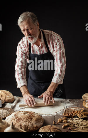 Erfahrene Bäcker Mann Vorbereitung Teig für hausgemachtes Brot in der Küche. Stockfoto