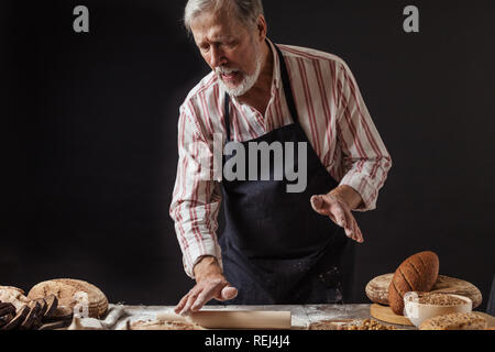 Erfahrene Bäcker Mann Vorbereitung Teig für hausgemachtes Brot in der Küche. Stockfoto