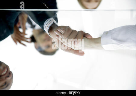 Hinter dem Glas. Handshake von Business Partnern Stockfoto