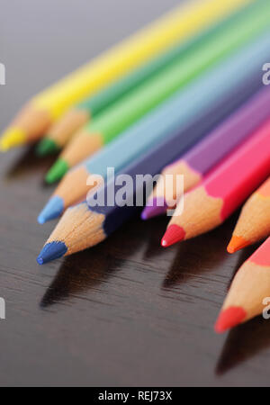 Nahaufnahme von Buntstiften auf hölzernen Schreibtisch Stockfoto
