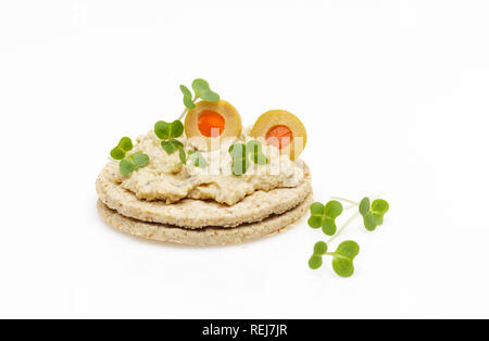 Glutenfreie haferplätzchen mit Hummus, Stil Houmous Oliven und Kresse auf weißem Hintergrund Stockfoto