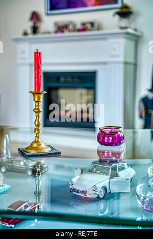 Interieur mit einem Glas Tisch und Kerzen und ein Kamin im Hintergrund Stockfoto