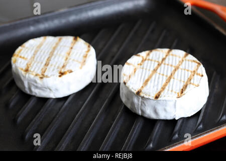 Lecker karierten Camembert Käse Braten auf Gusseisen Grillpfanne. Frische grillede Brie Käse Stockfoto