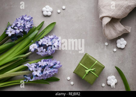 Blaue Hyazinthen Blumen, Keramik Frühling Dekorationen und wickelte Geschenkbox auf hellen Stein, Ansicht von oben Stockfoto