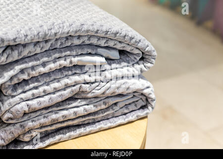 Gefaltete Velours Decke auf hölzernen Tisch bei Store Stockfoto