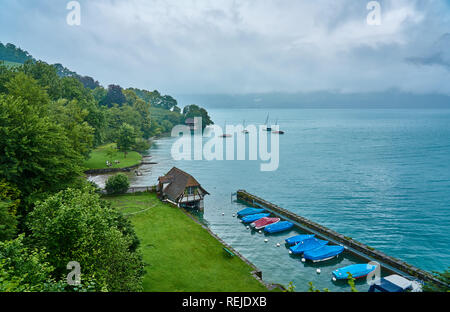 Landschaft des Thun Lake an einem regnerischen und nebligen Tag. Aufgenommen in Spiez, Schweizer Alpen, Schweiz Stockfoto