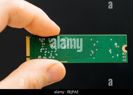 Mann Hand NVME PCIE SSD Festplatte mit hoher Lese- und Geschwindigkeit - grüne Platine schreiben Stockfoto