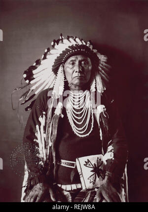 Hin-mah-auch-yah-lat-kekt, auch als Chief Joseph, Nez Perce Chief, sitzenden Portrait in traditioneller Kleidung, 1900 bekannt Stockfoto