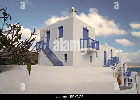 Häuser in Mykonos, Griechenland. Die weiß gekalkten Häuser mit blau gestrichenen Fenstern und Türen an sonnigen Himmel. Typische Architektur und Design. Sommer Urlaub auf der Mittelmeerinsel. Reisen und Reise Konzept. Stockfoto