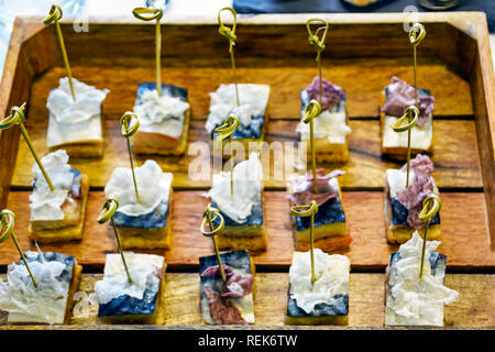 Catering Services Supply: Knoten der natürlichen Bambus Spieße in Makrele Fisch Häppchen platziert in einer Schale mit Holzbohlen an einem Business Event, Hotel serviert. Stockfoto