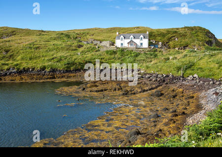 Blick auf eine traditionelle Hütte am Meer bei Ebbe an einem schönen Sommertag, von der Insel Scalpay, Äußere Hebriden, Schottland, Großbritannien Stockfoto