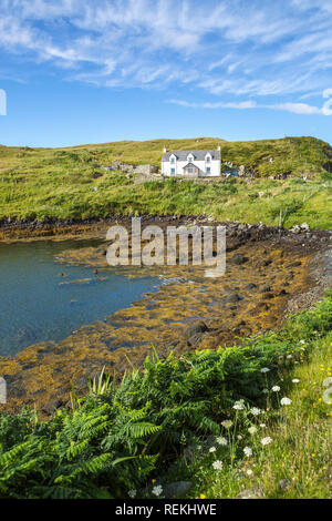 Blick auf eine traditionelle Hütte am Meer bei Ebbe an einem schönen Sommertag, von der Insel Scalpay, Äußere Hebriden, Schottland, Großbritannien Stockfoto