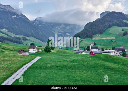 Landschaftspanorama der grünen Natur und Dorfhäuser bei Appenzell, Alpstein, Schweiz. Aufgenommen im Juni, im Sommer. Stockfoto