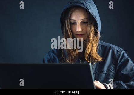 Mädchen Hacker verwendet ein Laptop das System zu hacken. Diebstahl persönlicher Daten. Schaffung und Infektion der bösartigen Virus. Das Konzept der Internetkriminalität und hackin Stockfoto