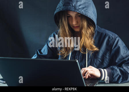 Mädchen Hacker verwendet ein Laptop das System zu hacken. Diebstahl persönlicher Daten. Schaffung und Infektion der bösartigen Virus. Das Konzept der Internetkriminalität und hackin Stockfoto