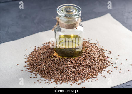 Leinsamen und Leinöl goldenes Öl in einer Glasflasche auf dem Tisch. Das Konzept gesunde Ernährung mit Omega 3 Fettsäuren. Stockfoto