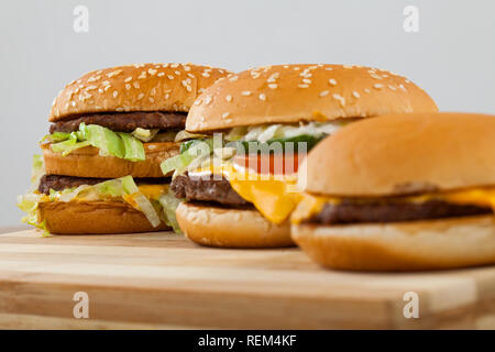 Drei verschiedene Art und Größe der leckeren Burger auf einem Holzbrett Stockfoto