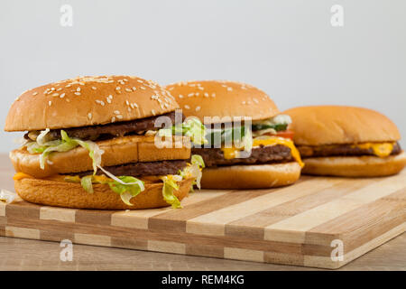 Drei verschiedene Art und Größe der leckeren Burger auf einem Holzbrett Stockfoto