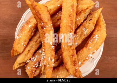 Eine Nahaufnahme der traditionellen spanischen Porras, einem typischen Madrider Sonntag Frühstück, Schuß von der Oberseite in einem dunklen Holzmöbeln im Landhausstil Hintergrund Stockfoto